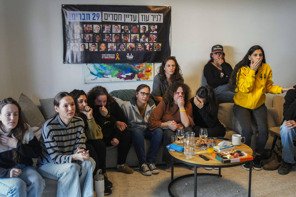 Freed hostage Shani Goren, fourth left, and friends of Israeli hostage Arbel Yehoud react as th ...