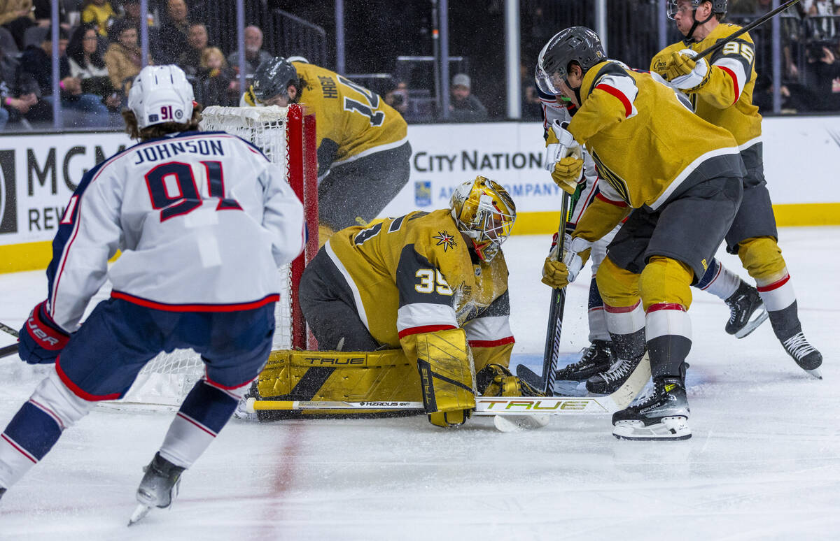 Golden Knights goaltender Ilya Samsonov (35) smothers the puck as Columbus Blue Jackets center ...