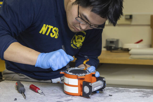 National Transportation Safety Board (NTSB) investigators examine cockpit voice recorder and fl ...