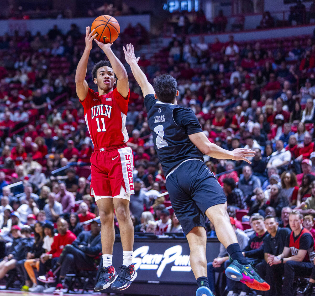 UNLV Rebels guard Dedan Thomas Jr. (11) elevates to shoot over UNR guard Jarod Lucas (2) during ...