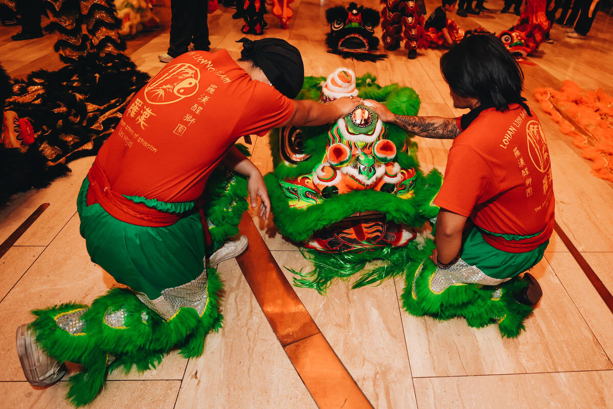 Dancers pray over their costumes before taking part in a Lunar New Year parade featuring tradit ...