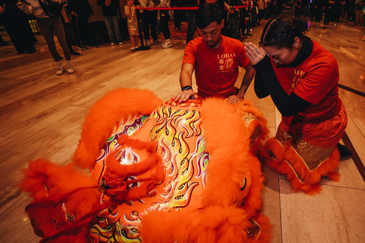 Dancers pray over their costumes before taking part in a Lunar New Year parade featuring tradit ...