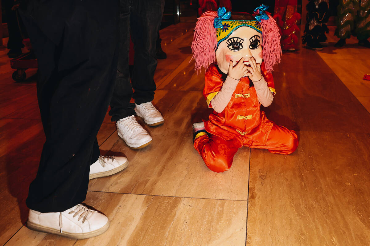 A child peeks out from their costume during a Lunar New Year parade featuring traditional dance ...