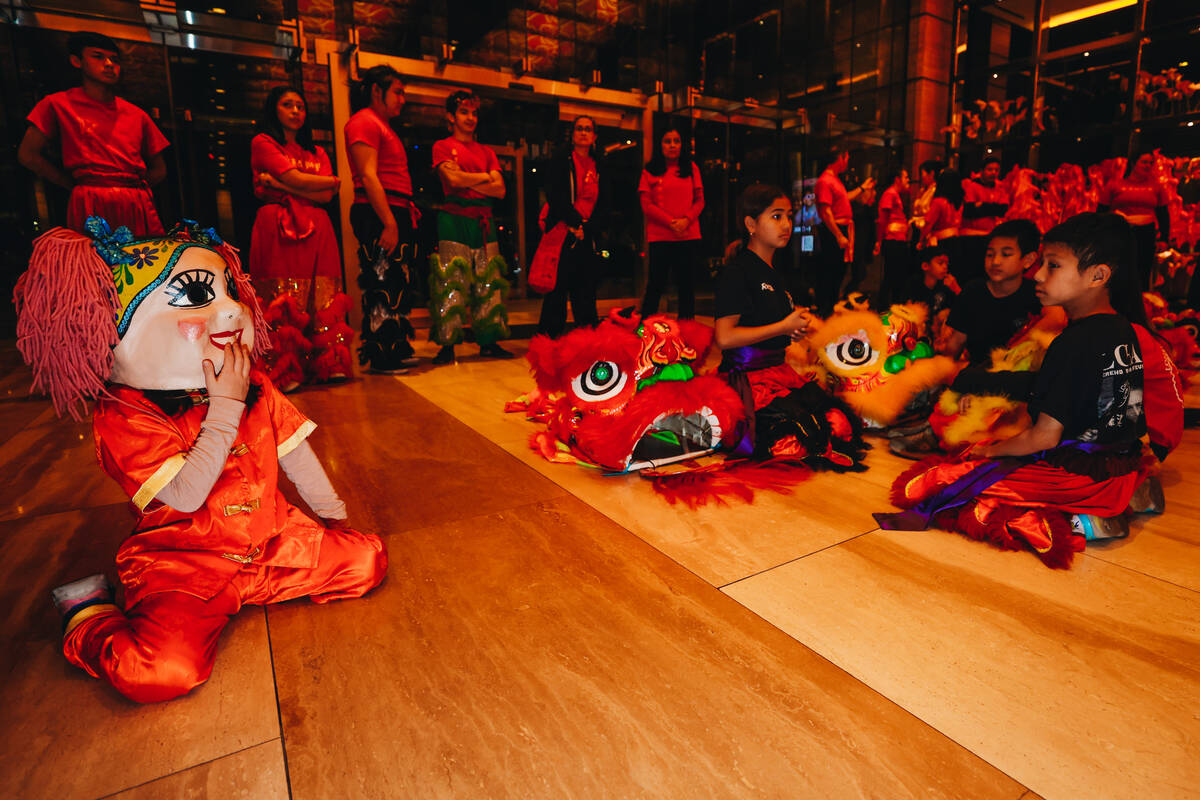 Dancers sit on the ground waiting to perform during a Lunar New Year parade featuring tradition ...