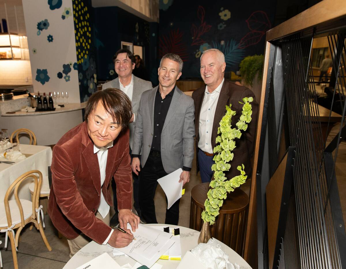 Hideyuki Takahashi, front, owner of Stix Asia, signs the agreement for the Asian food hall from ...