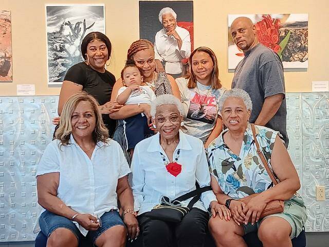 Lorell Guydon poses with four of her nieces, one grandniece and a family friend by a portrait o ...