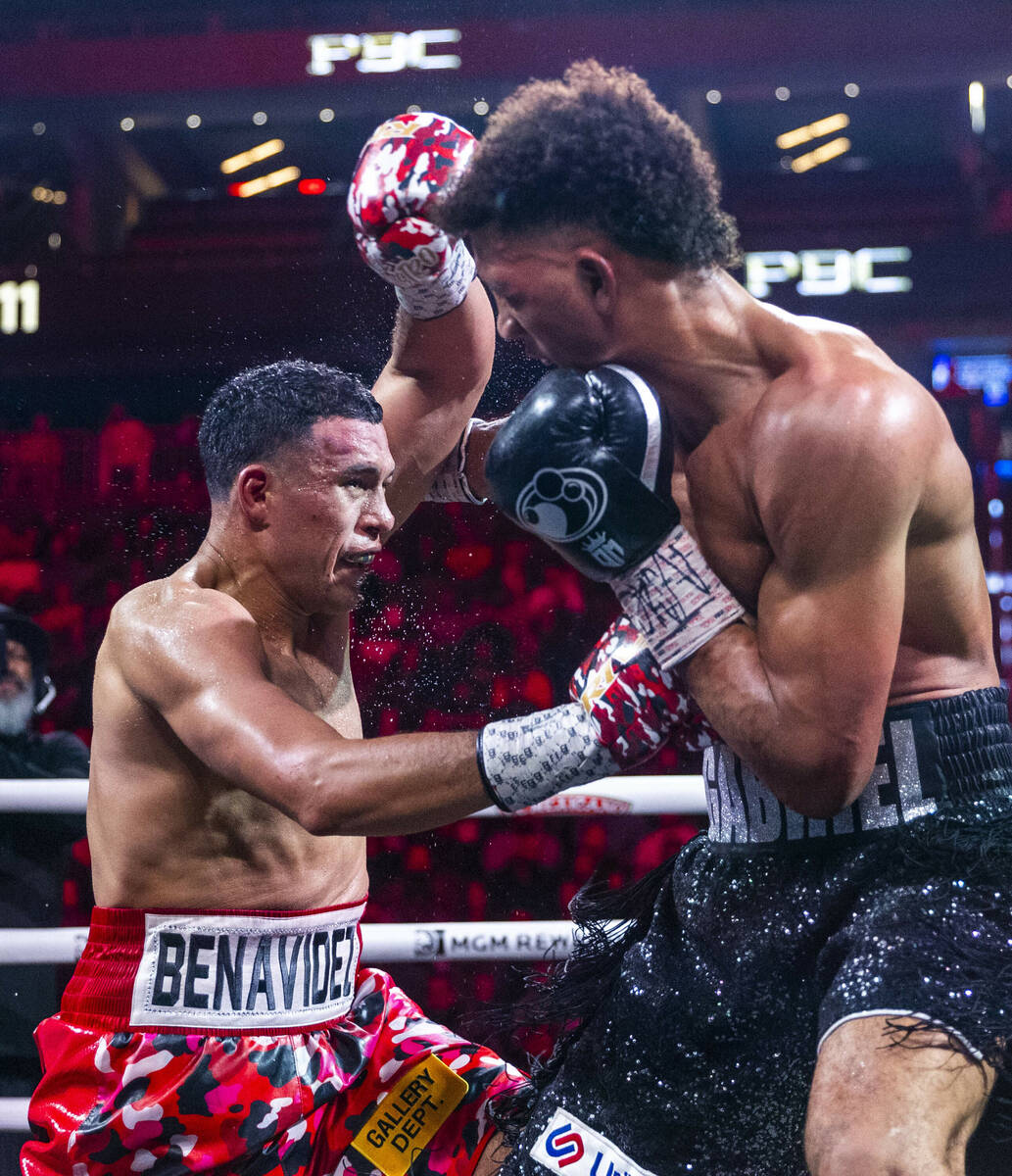 David Benavidez connects with the body of David Morrell Jr. in round 11 of their WBC and WBA ti ...
