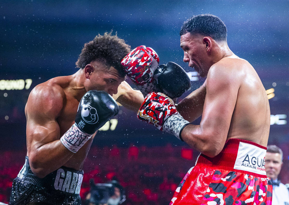 David Morrell Jr. and David Benavidez trade punches in round 7 of their WBC and WBA title fight ...