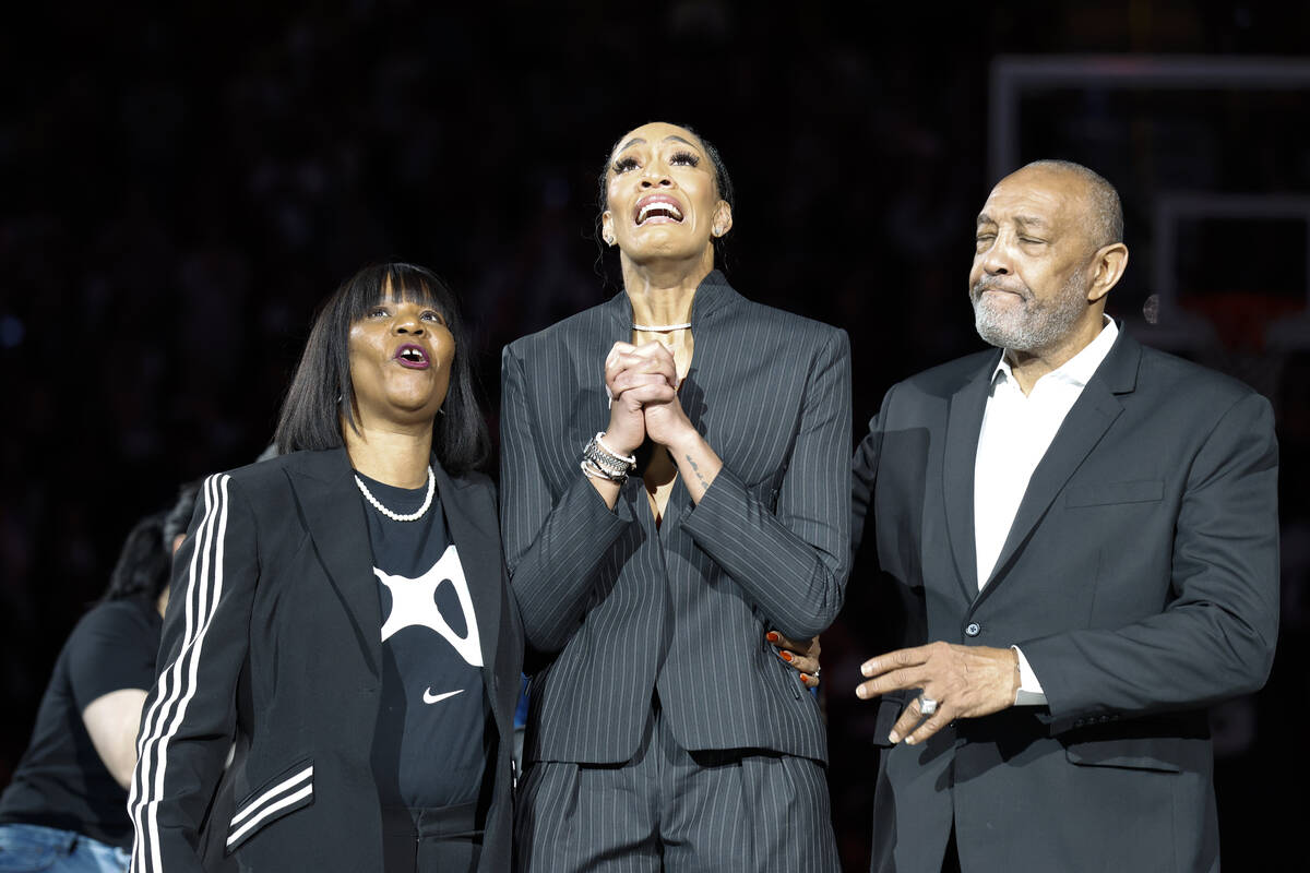 A'ja Wilson, center, stands with her parents Eva and Roscoe Wilson as they watch her number be ...