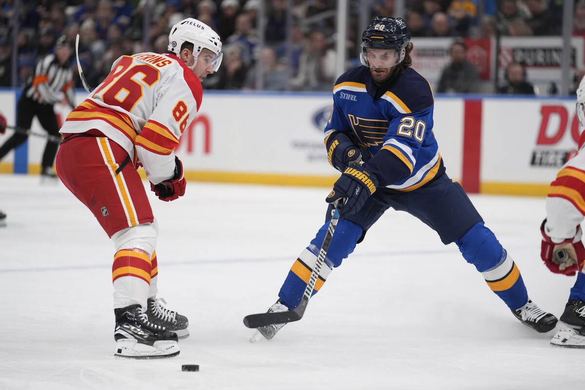 St. Louis Blues' Brandon Saad (20) reaches for a loose puck as Calgary Flames' Rory Kerins (86) ...