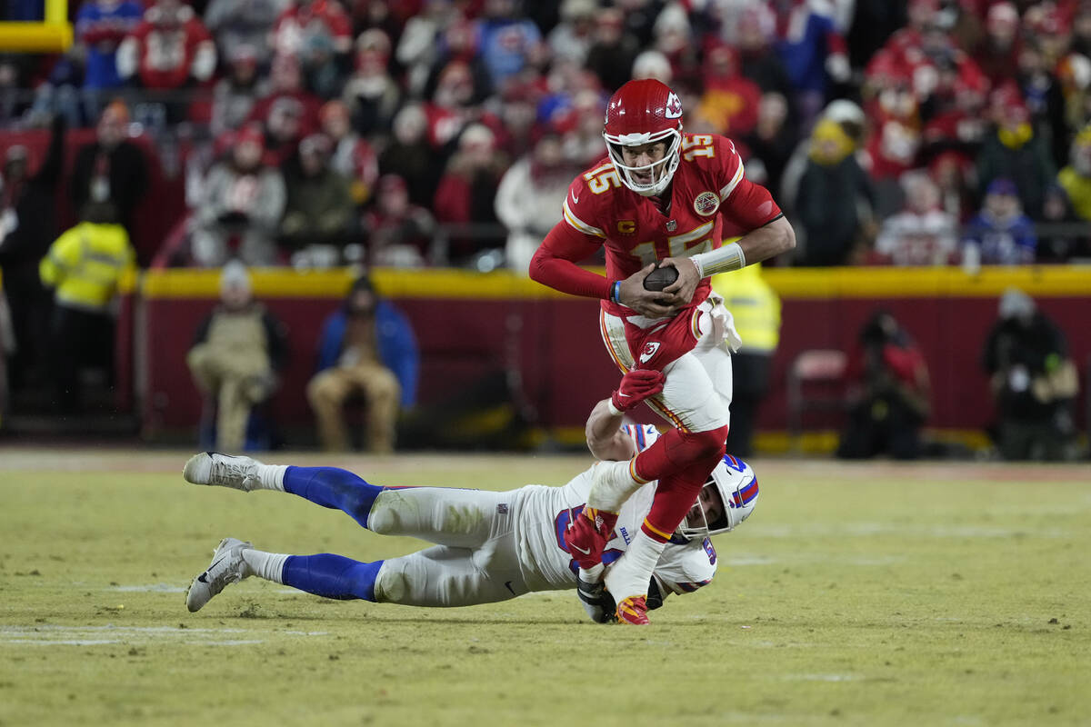 Kansas City Chiefs quarterback Patrick Mahomes (15) tries to avoid a tackle by Buffalo Bills li ...