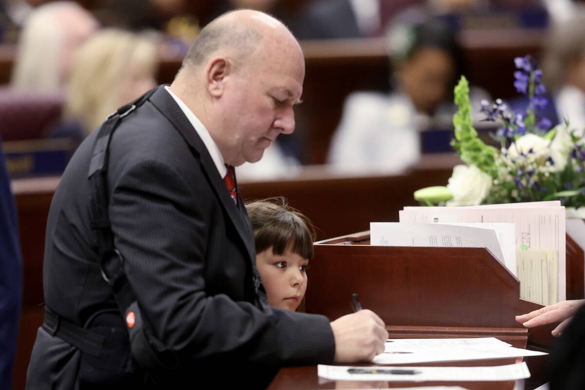 Assembly member Ken Gray, R-Dayton, signs paperwork with his niece Olivia Parker, 8, on the Ass ...