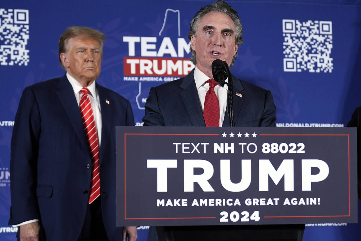 Then-presidential candidate Donald Trump listens as then-North Dakota Gov. Doug Burgum, who is ...