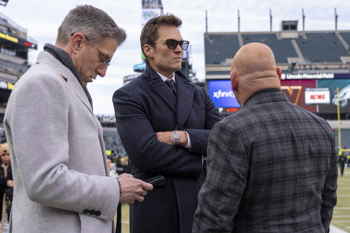 Fox Sports host Kevin Burkhardt, left, and Tom Brady, center, looks on with Jay Glazer, right, ...