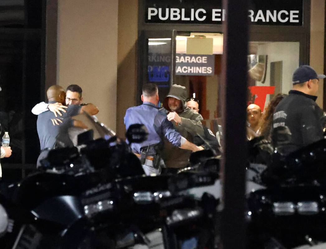 Police officers comfort each other as they gathered outside of UMC where a North Las Vegas poli ...