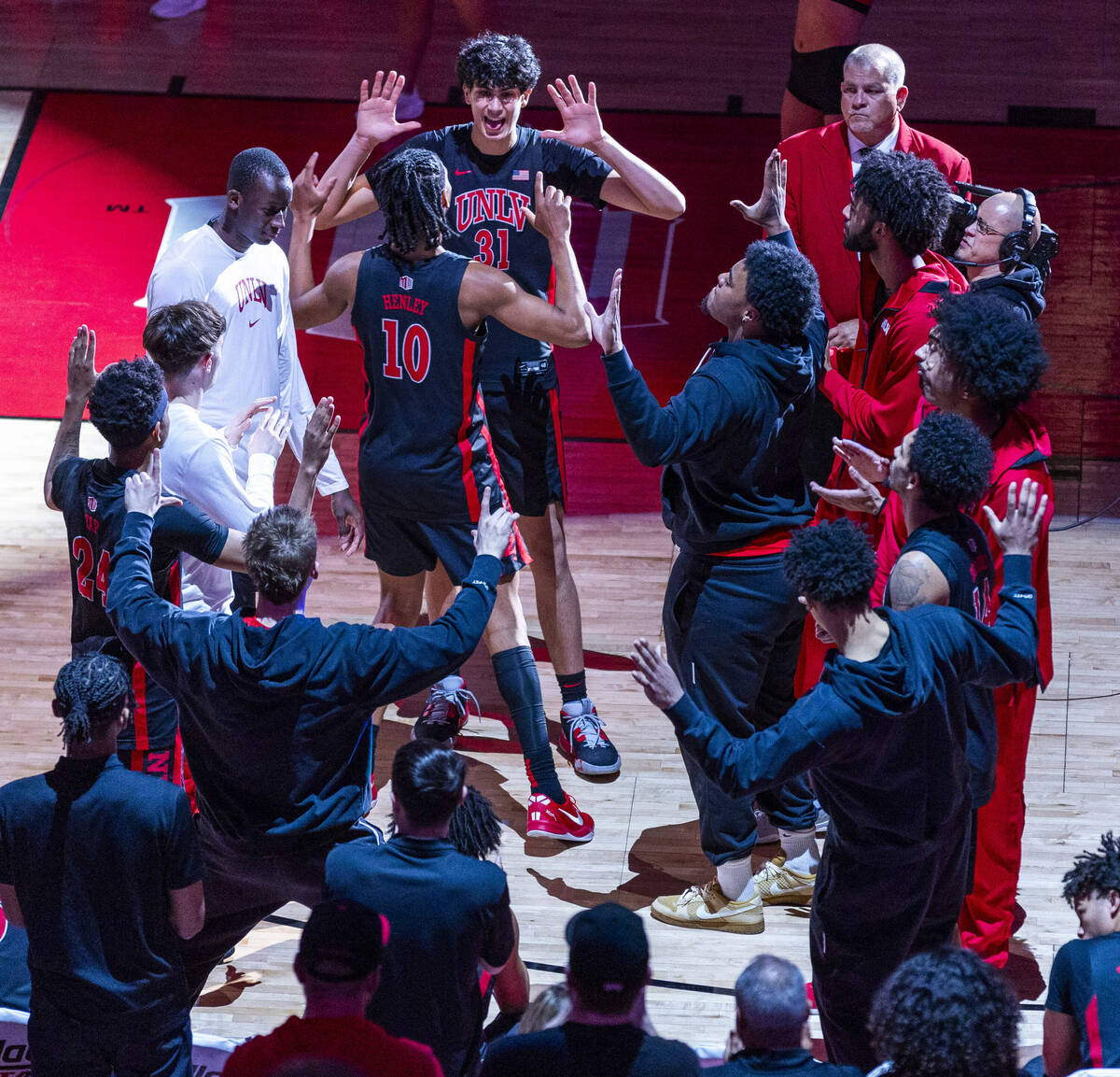 UNLV guard Jaden Henley (10) is celebrated by forward Faris Mucharbach (31) and teammates for i ...