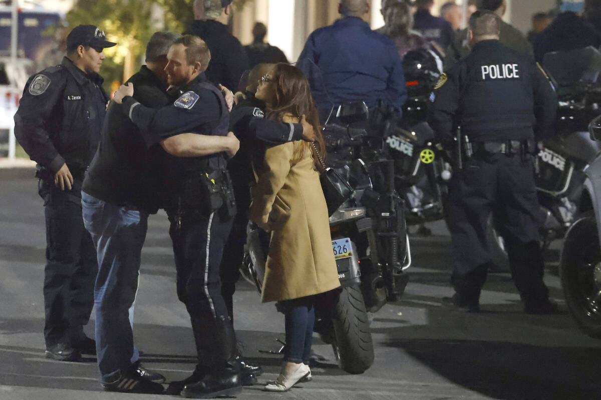 Police officers comfort each other as they gather outside of UMC where a North Las Vegas police ...