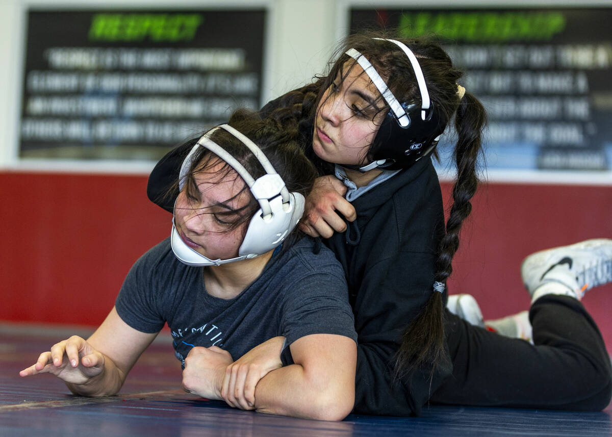Noelani Lutz is wrapped up from behind by Mika Yoffee during girl's wrestling practice in the c ...