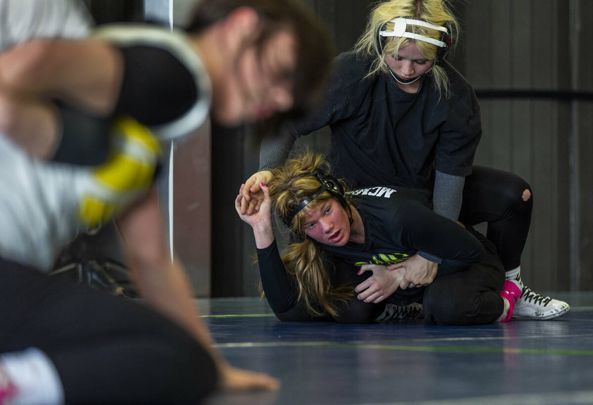 Roni McMillian works to escape from beneath Billie Bonwell during girl's wrestling practice in ...