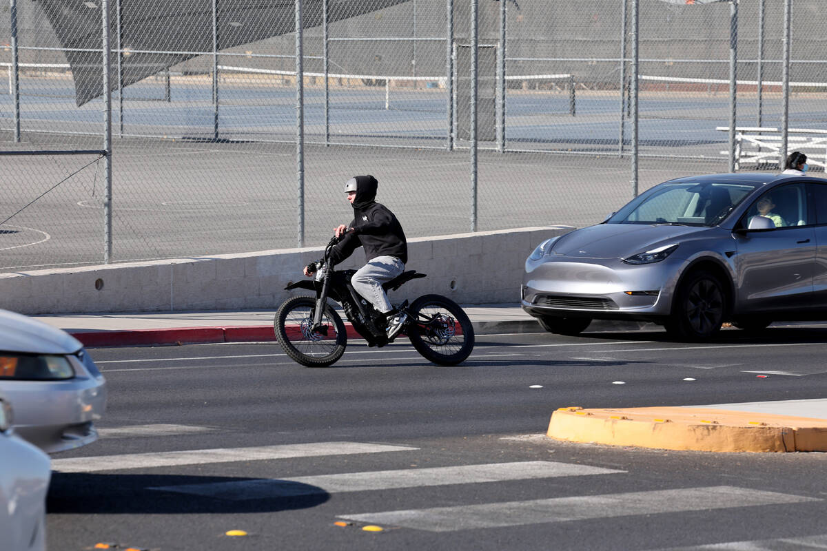 A student rides an e-dirt bike on Coronado Center Drive outside Coronado High School in Henders ...
