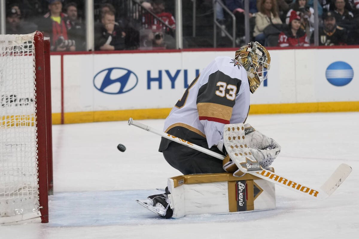 Vegas Golden Knights goaltender Adin Hill, right, deflects a shot during the second period of a ...