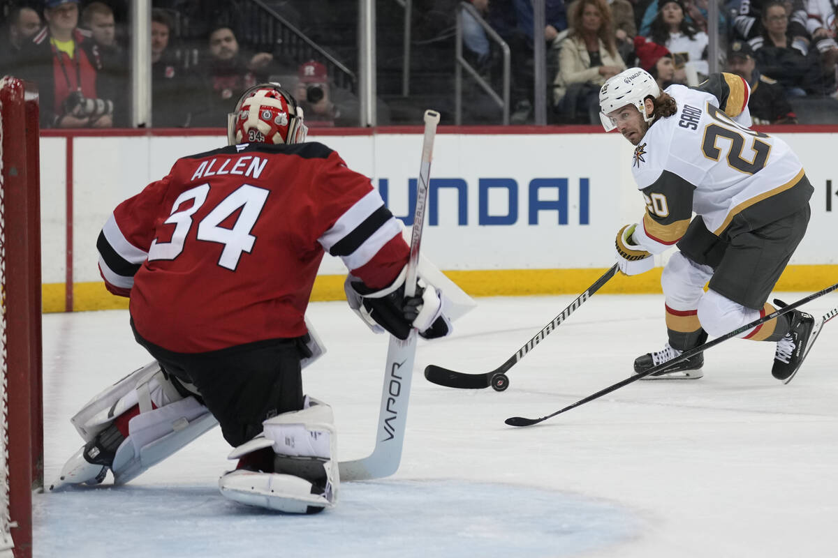 Vegas Golden Knights' Brandon Saad, right, looks for a shot on New Jersey Devils goaltender Jak ...