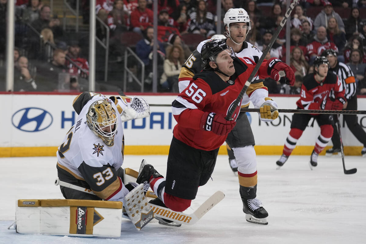 New Jersey Devils' Erik Haula, center, gets tripped up by Vegas Golden Knights goaltender Adin ...