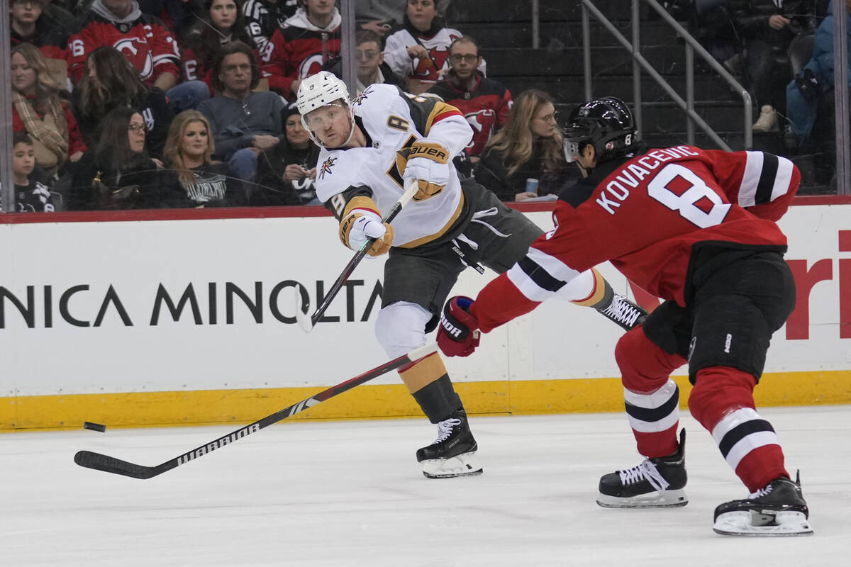 Vegas Golden Knights' Jack Eichel, left, shoots past New Jersey Devils' Johnathan Kovacevic (8) ...
