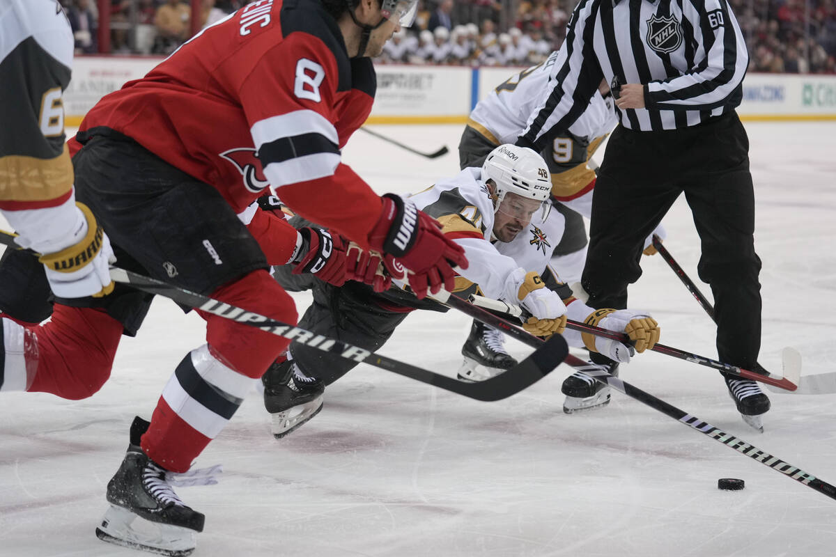 Vegas Golden Knights' Tomas Hertl, bottom right, dives for a puck during a face-off during the ...