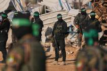 FILE - Hamas fighters take up positions ahead of a hostage release in Khan Younis, southern Gaz ...