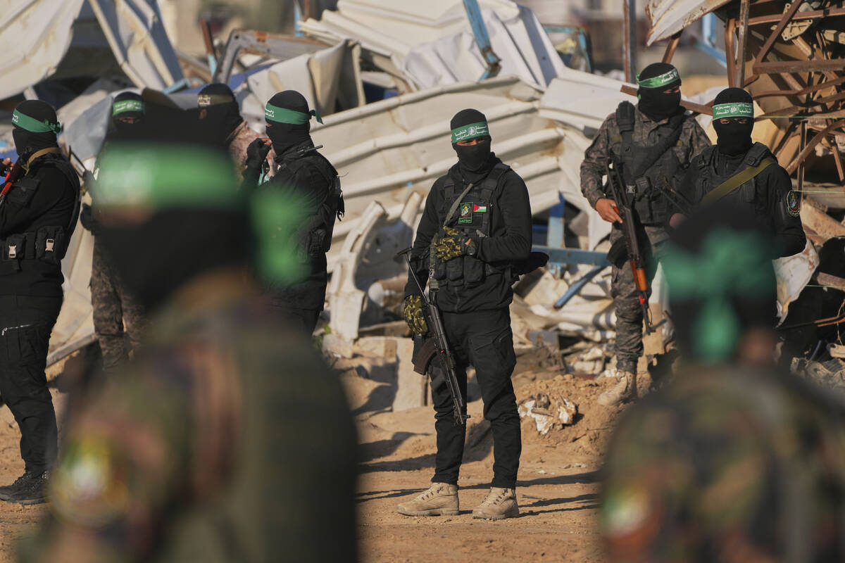 FILE - Hamas fighters take up positions ahead of a hostage release in Khan Younis, southern Gaz ...