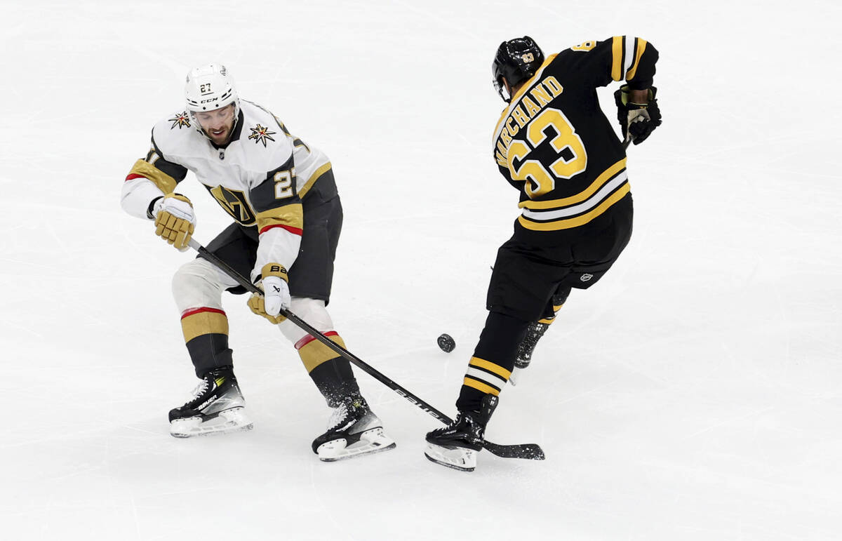 Vegas Golden Knights defenseman Shea Theodore (27) and Boston Bruins left wing Brad Marchand (6 ...