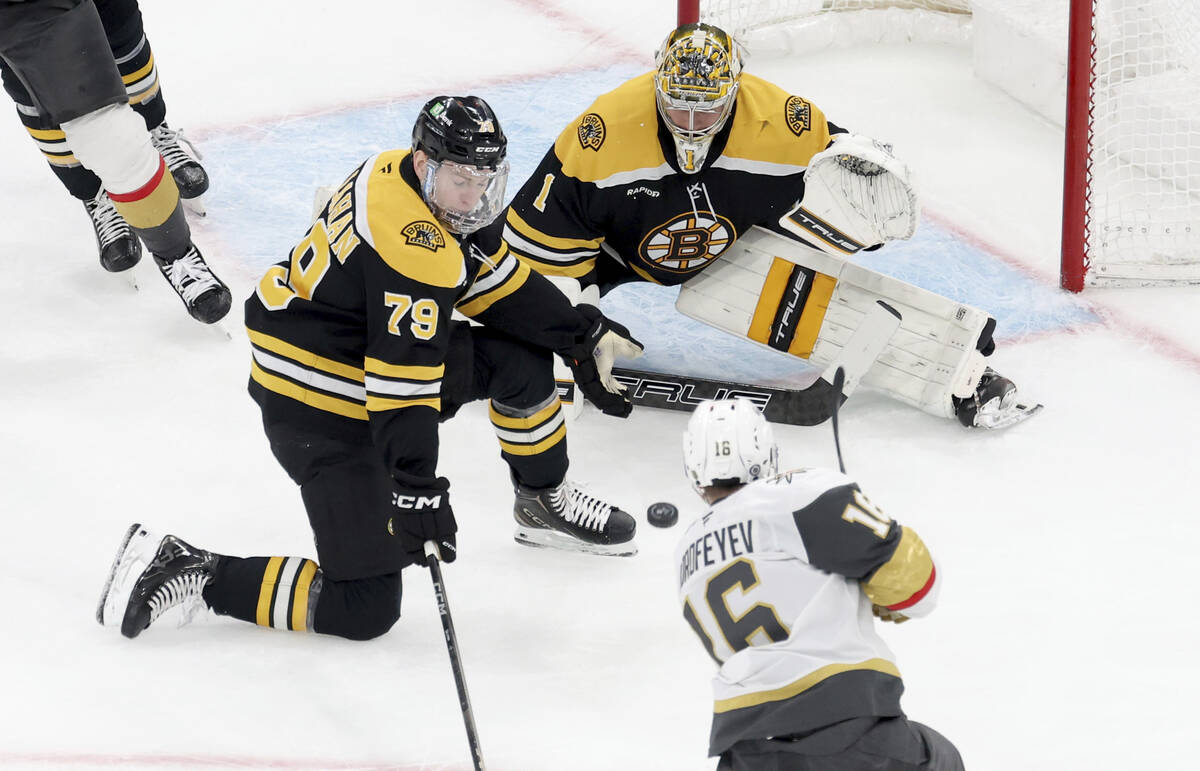 Boston Bruins defenseman Michael Callahan (79) and goaltender Jeremy Swayman (1) defend the net ...