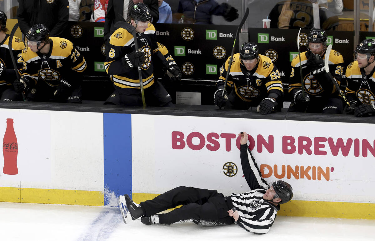 A game official falls to the ice during the first period of an NHL hockey game between the Bost ...