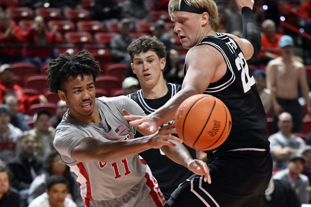 UNLV guard Dedan Thomas Jr. (11) passes the ball around Utah State forward Karson Templin (22) ...