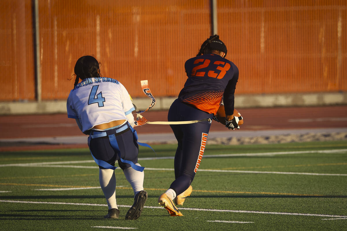 Legacy's Savannah Kaina (23) scores a touchdown under pressure from Canyon Springs' Priscilla R ...