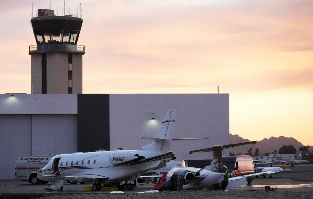 A damaged Learjet, right, sits damaged after colliding with a parked jet at Scottsdale Airport ...