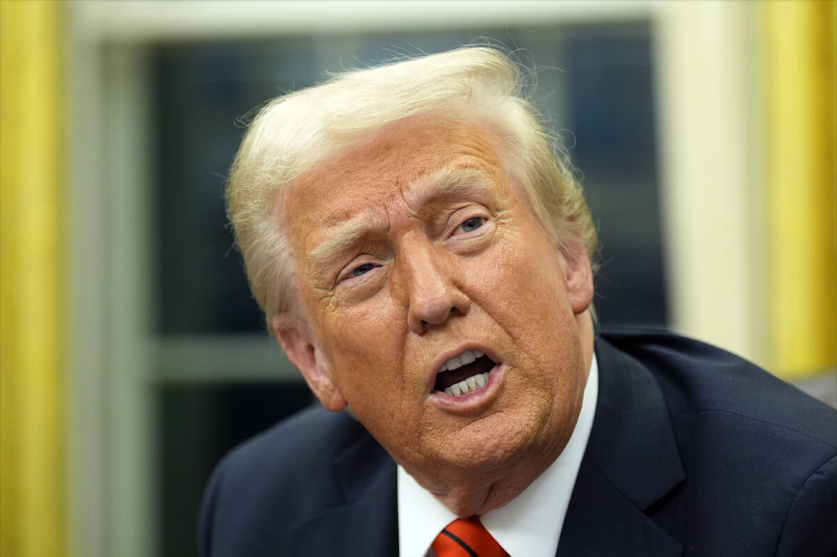 President Donald Trump speaks with reporters as he signs executive orders in the Oval Office at ...