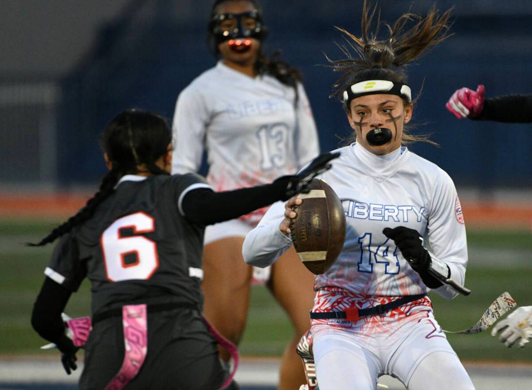 Liberty quarterback Kaylie Phillips looks to get past Bishop Gorman’s Eden Amina during the 5 ...