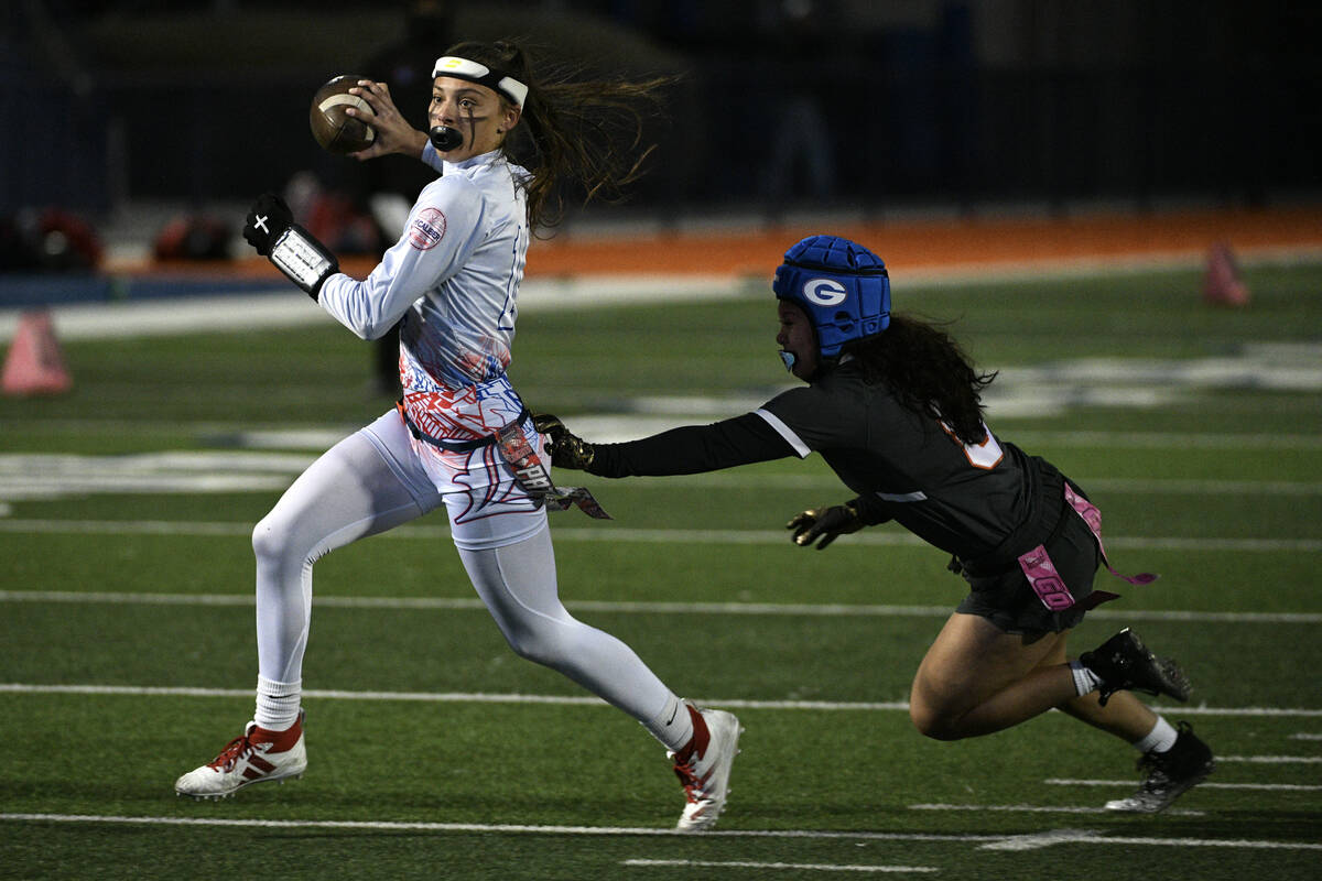 Liberty quarterback Kaylie Phillips escapes a tackle by Bishop Gorman’s Chloe Mead durin ...