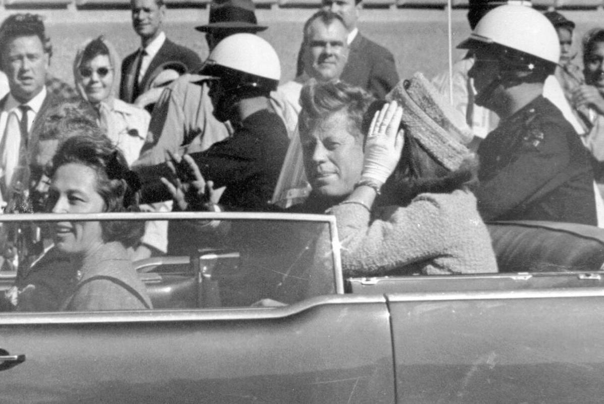 President John F. Kennedy waves from his car in a motorcade in Dallas, with first lady Jacqueli ...