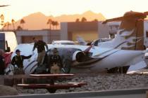 Scottsdale Fire Department firefighters work on a crashed Learjet at Scottsdale Airport after i ...