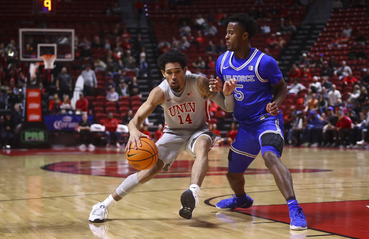 UNLV guard Jailen Bedford (14) drives to the ball against Air Force guard Ethan Taylor (5) duri ...