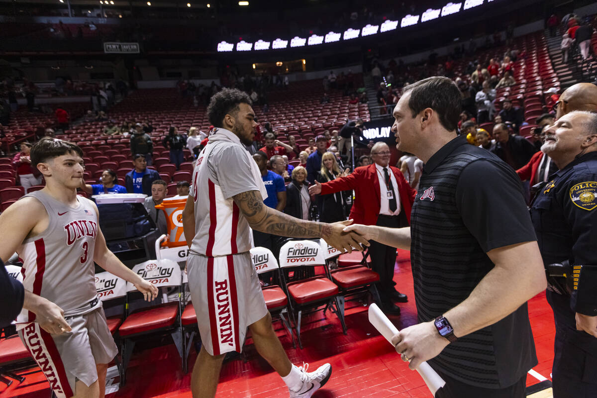 UNLV head coach Kevin Kruger celebrates the team’s win over Air Force with UNLV forward ...