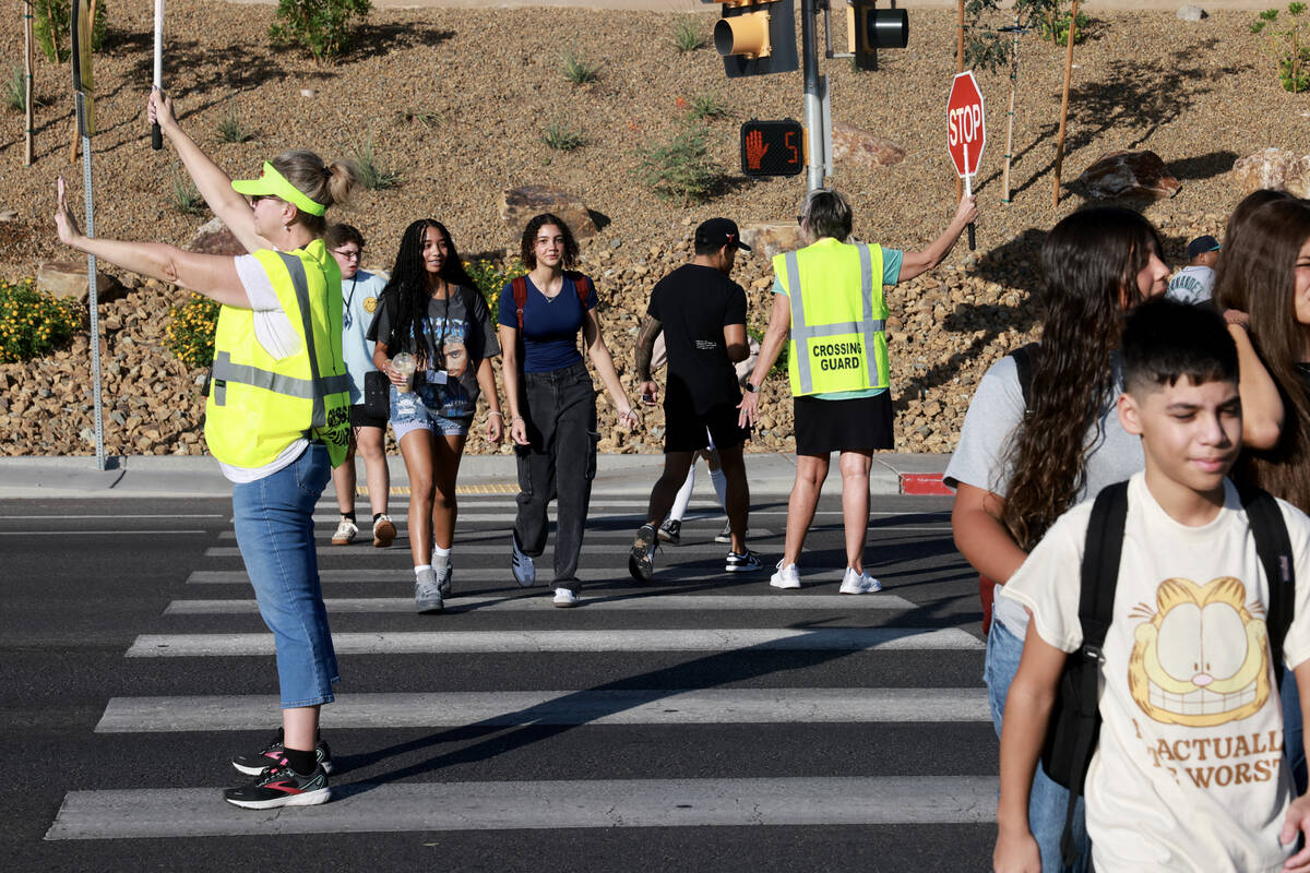Crossing guards Sonja Castleman, left, and Cindy Branby help students get across the street on ...