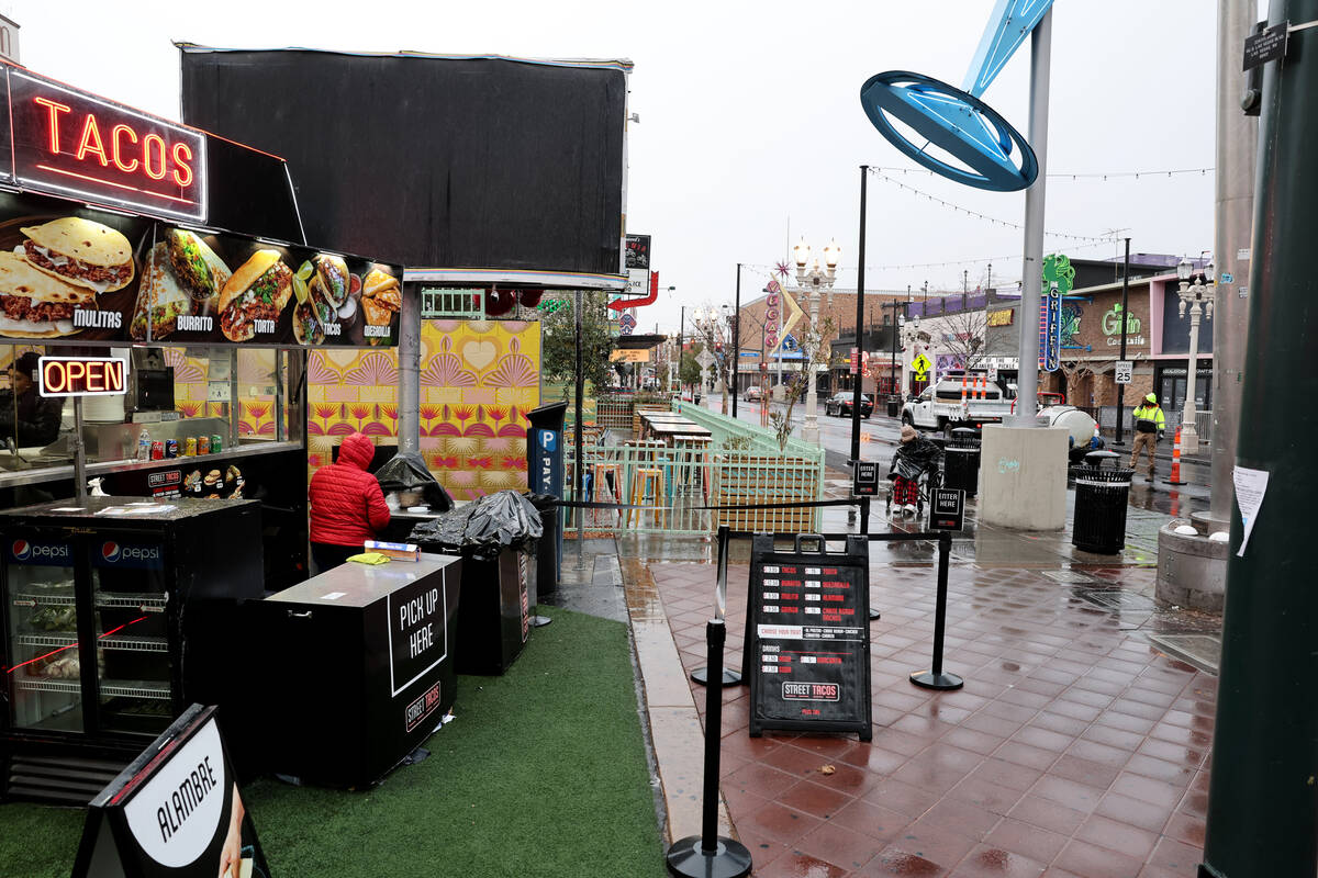 A worker covers equipment at a food trailer at Las Vegas Boulevard and Fremont street in Las Ve ...