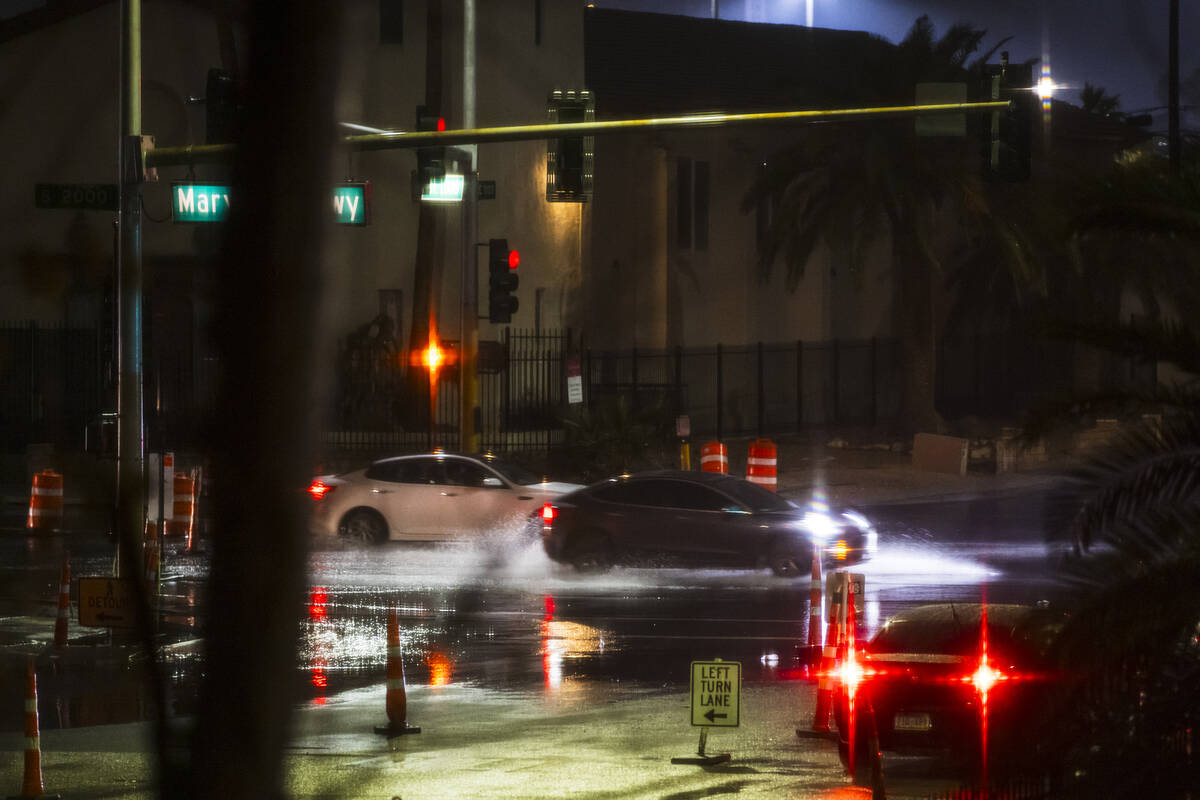 Cars drive along Maryland Parkway at St. Louis Avenue as rain comes down in Las Vegas on Thursd ...