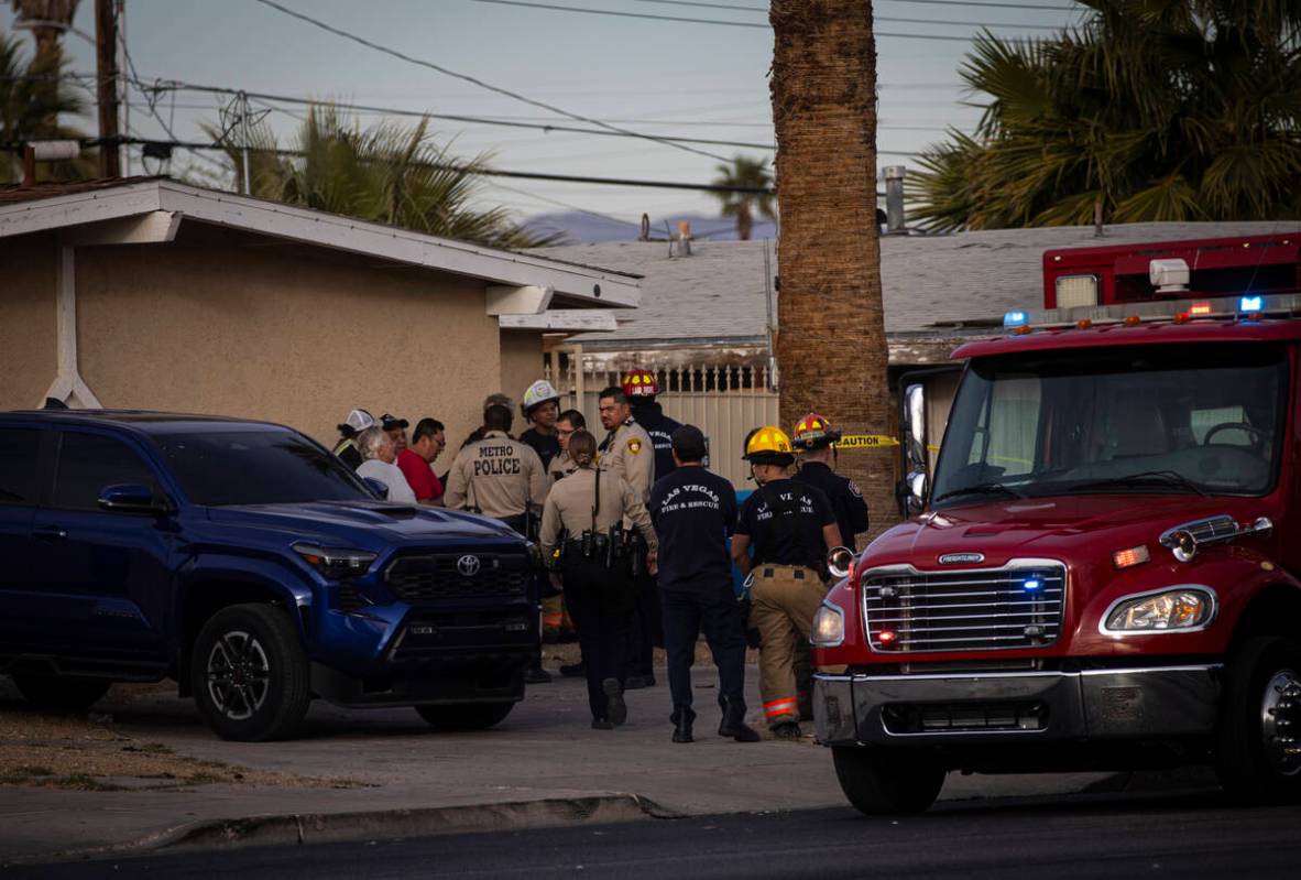 Las Vegas police and firefighters talk with people in the area after an unconscious man who was ...
