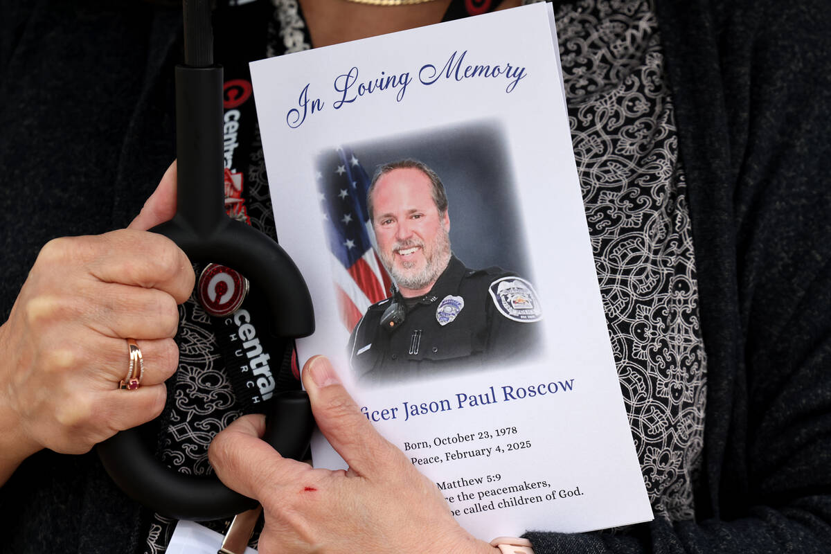 A church staff member holds a program for the celebration of life service for fallen North Las ...