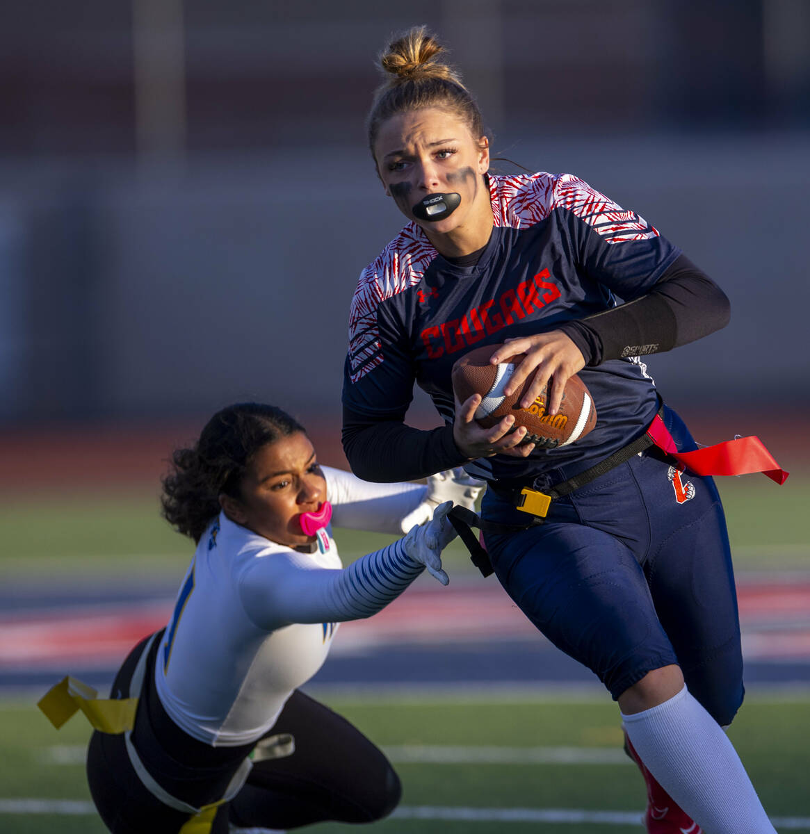 Coronado quarterback Bailey Goldberg (1) looks to evade a stop by Sierra Vista defender Lydia M ...